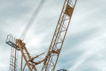 orange and gray crane under cloudy sky during daytime
